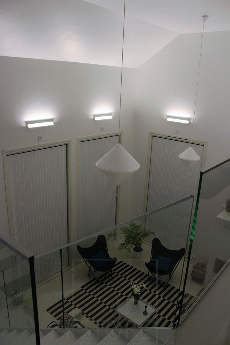 A living room with atmospheric indirect lighting created with Led BLADE wall lamps. The luminaire is mounted to illuminate from the bottom up, and thus the indirect lighting also emphasises the height of the space. Ledstore.fi