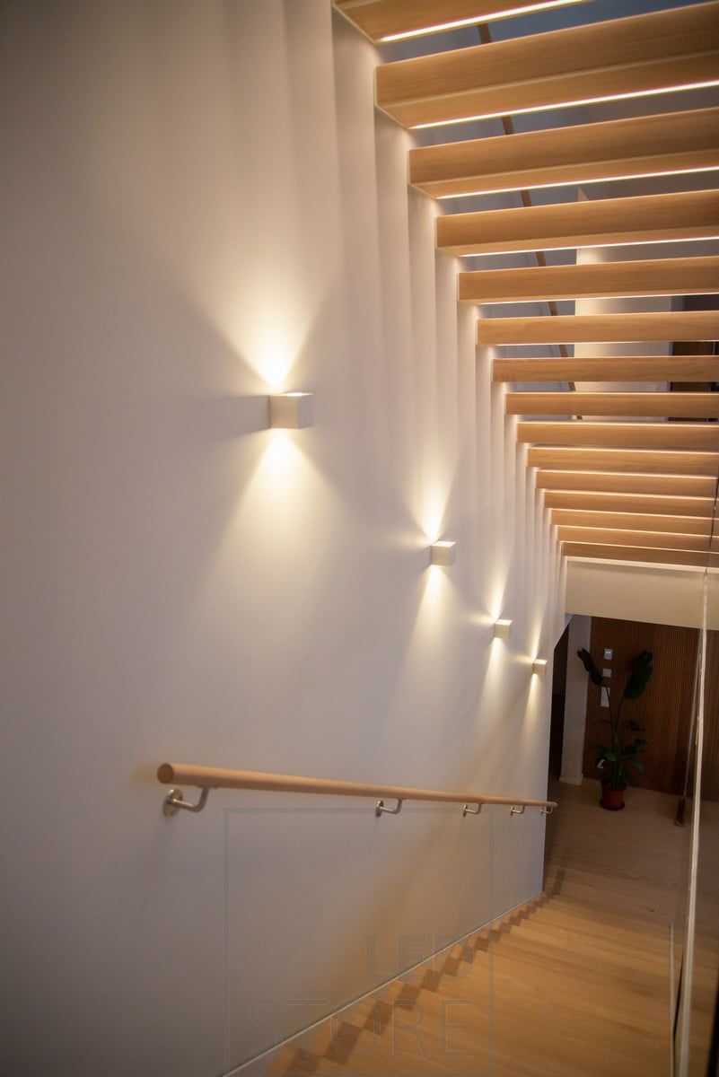 The staircase is illuminated and accentuated by CUBIC bi-directional wall luminaires. Ledstore.fi