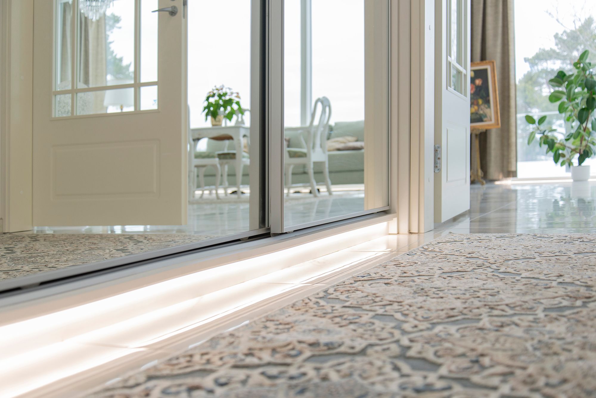 An LED strip at the base of the hallway cabinet provides indirect, soft mood lighting through the floor. Ledstore.fi