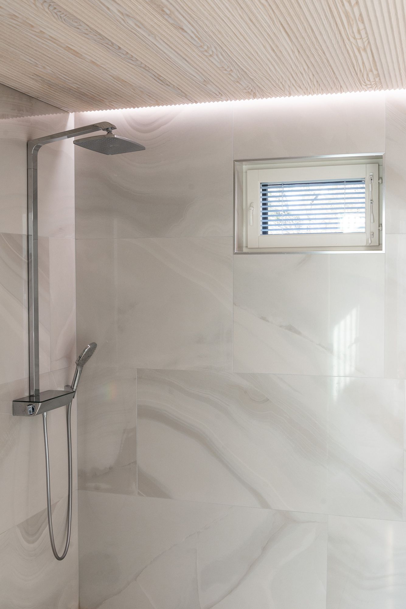 Led strip between the ceiling and the wall indirectly illuminating the shower, creating a spa atmosphere. Ledstore.fi