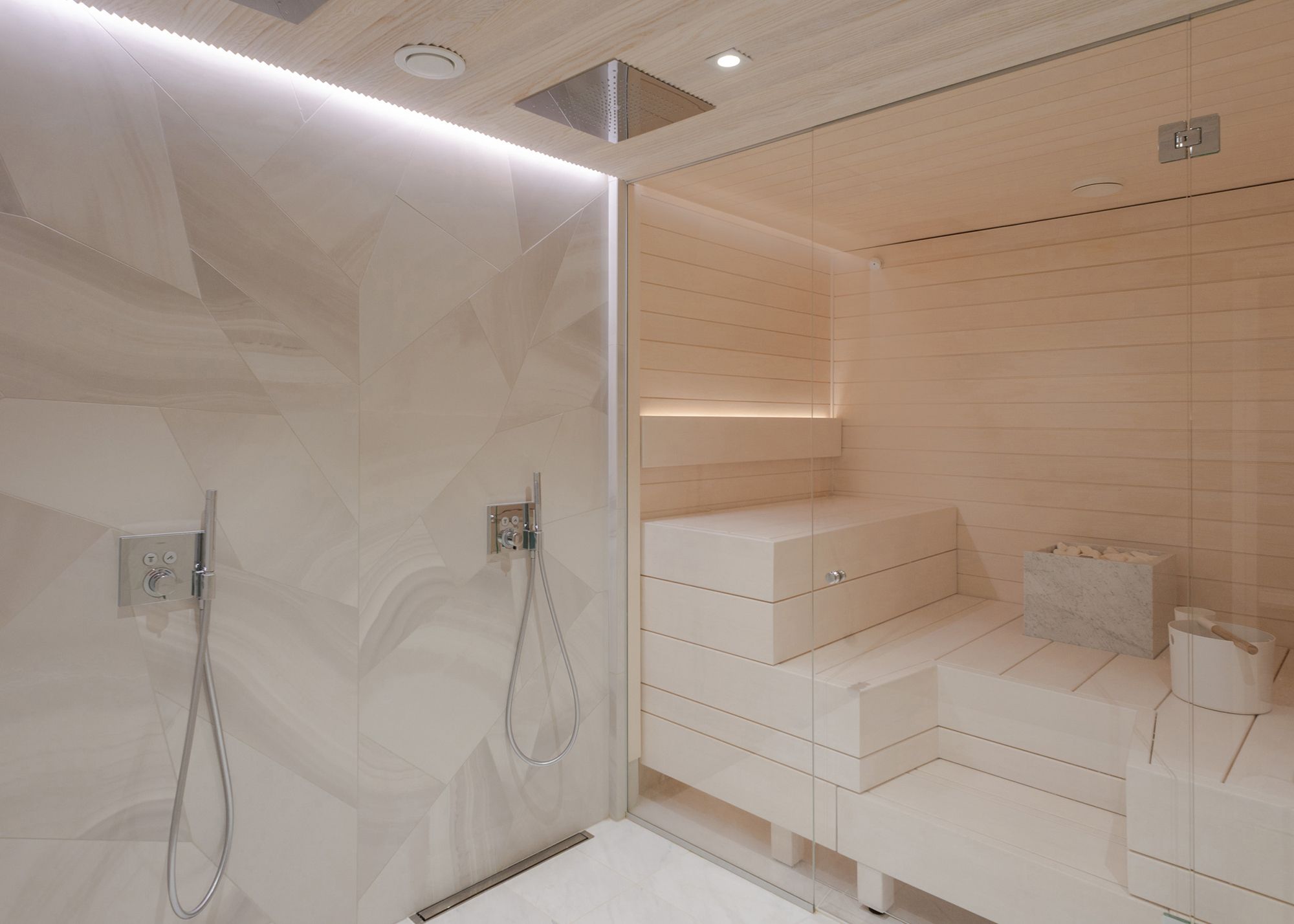 Shower wall accented by a led strip between the ceiling and the wall. In the sauna, a led strip illuminates the back of the backrest. Ledstore.fi
