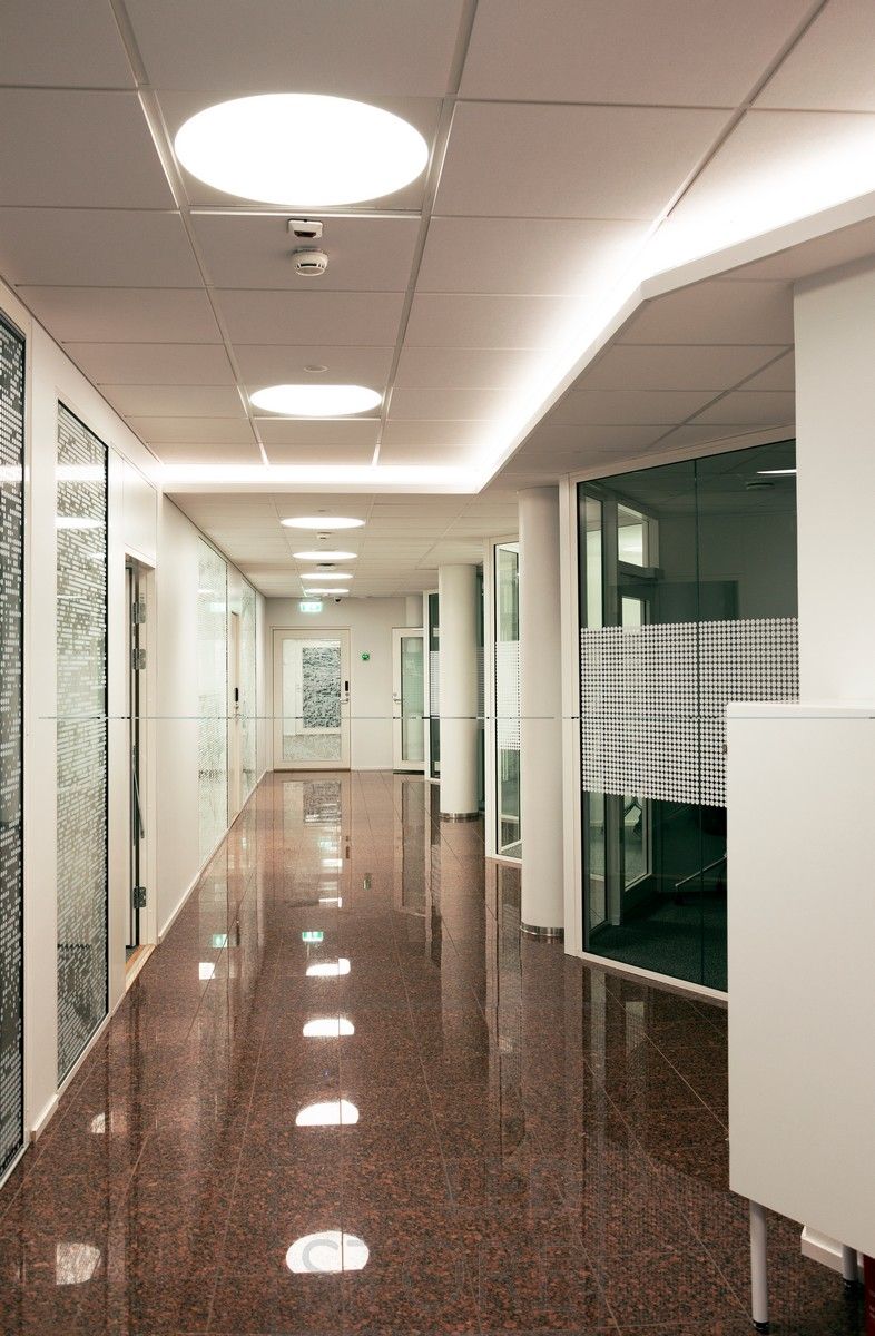 Led strip mounted on the downlight of a corridor creating atmospheric indirect light through the ceiling. General lighting implemented with recessed Plafondi luminaires.