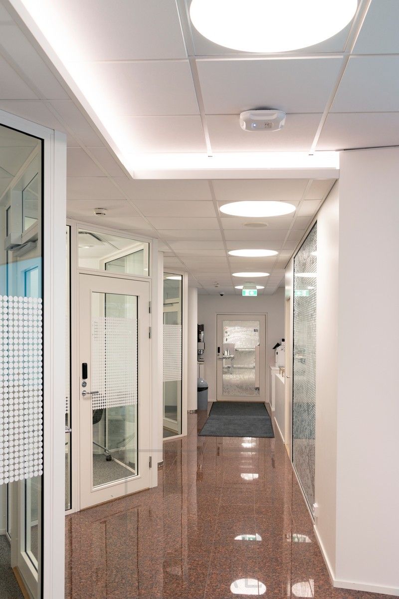 Led strip mounted on the downlight of a corridor to create a moody indirect light. General lighting implemented with recessed Plafondi luminaires.