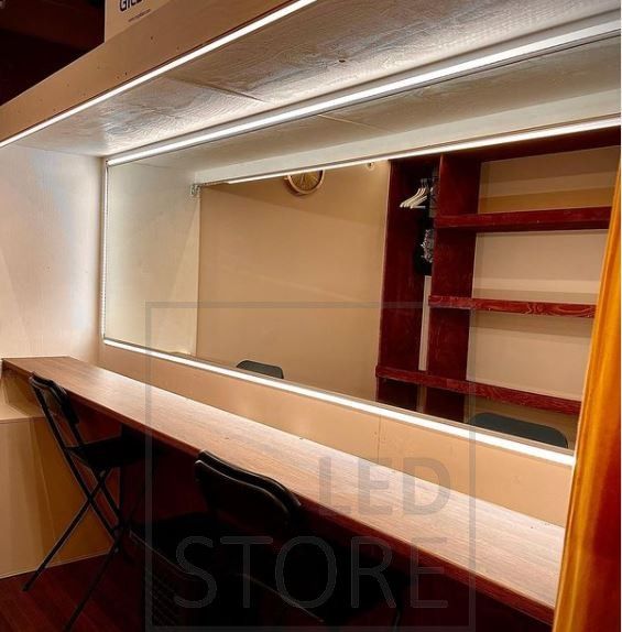 Home gym illuminated with spotlights and atmospheric indirect light. Indirect lighting is achieved with a LED strip light installed between the ceiling and the wall.