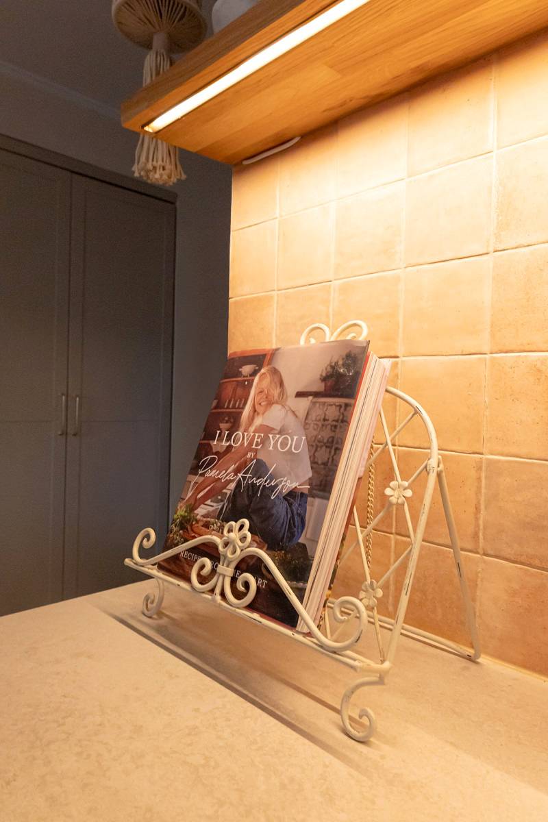 A LED strip light installed under a shelf illuminates the kitchen level.