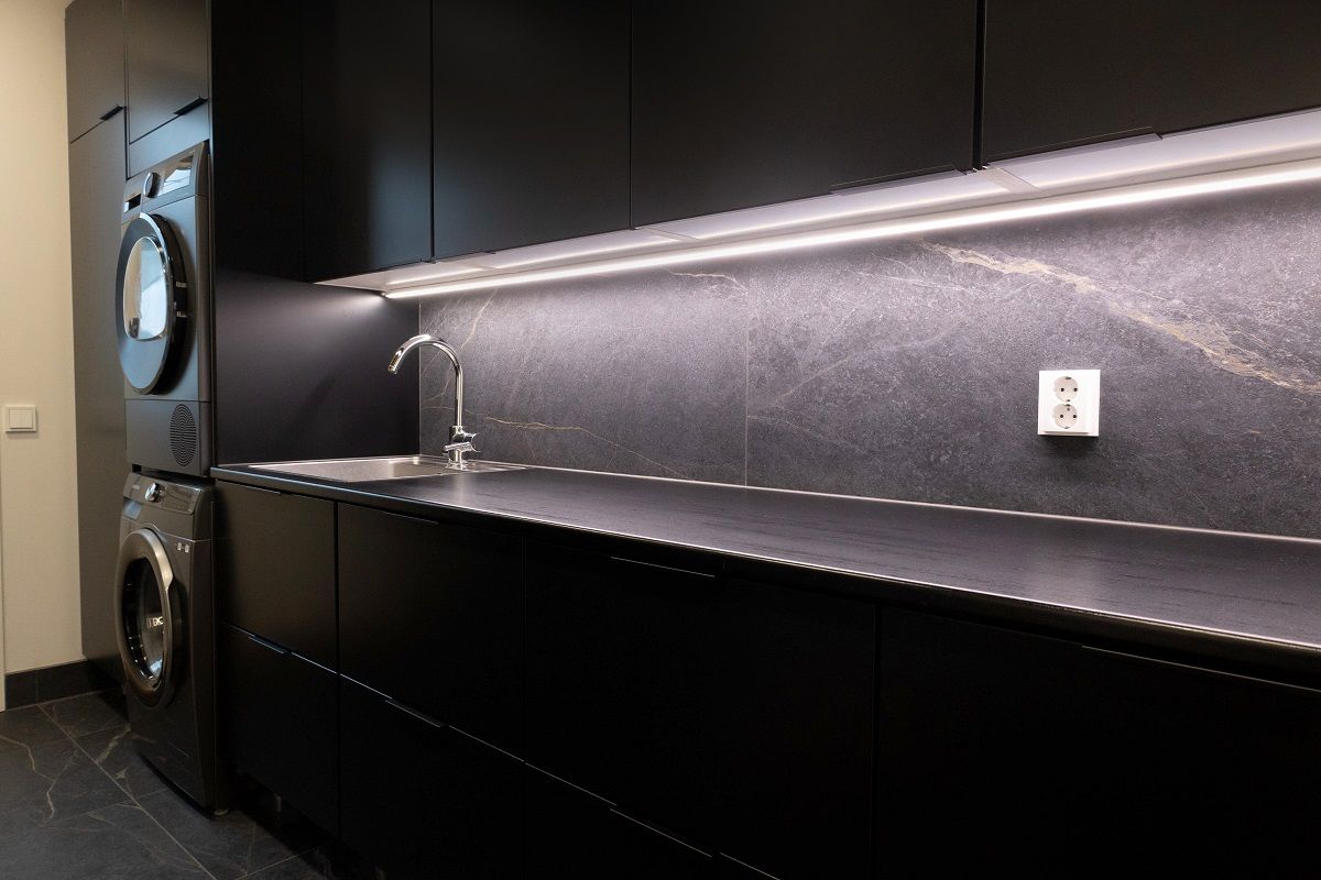 LED strip illuminates the worktop in a utility room.