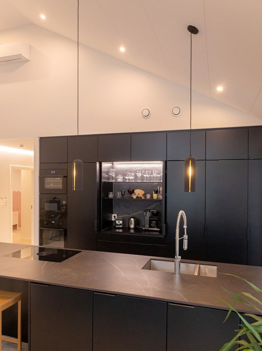 Breakfast cabinet with LED strip lighting and spotlights on the sloping ceiling of the kitchen.