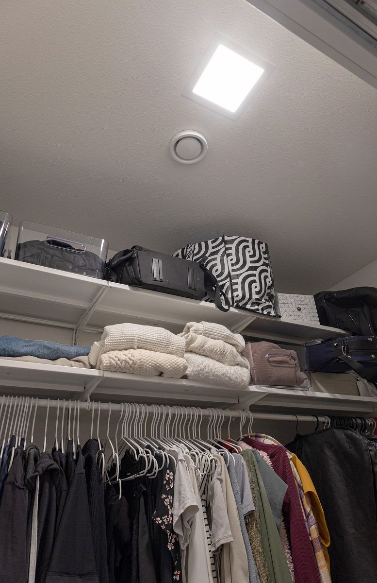 A small rectangular LED panel flush mounted in the ceiling of a wardrobe.