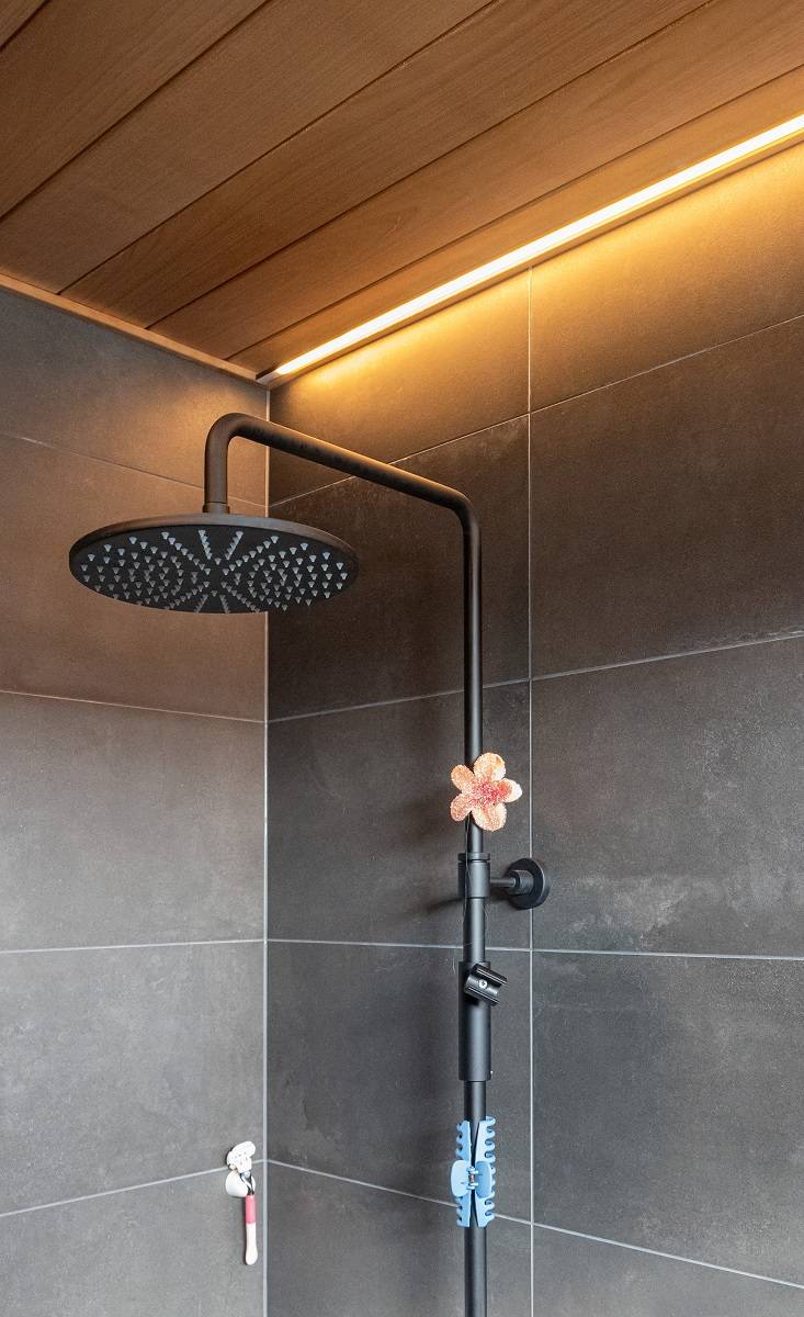 Bathroom with LED strip recessed in the ceiling next to the wall.