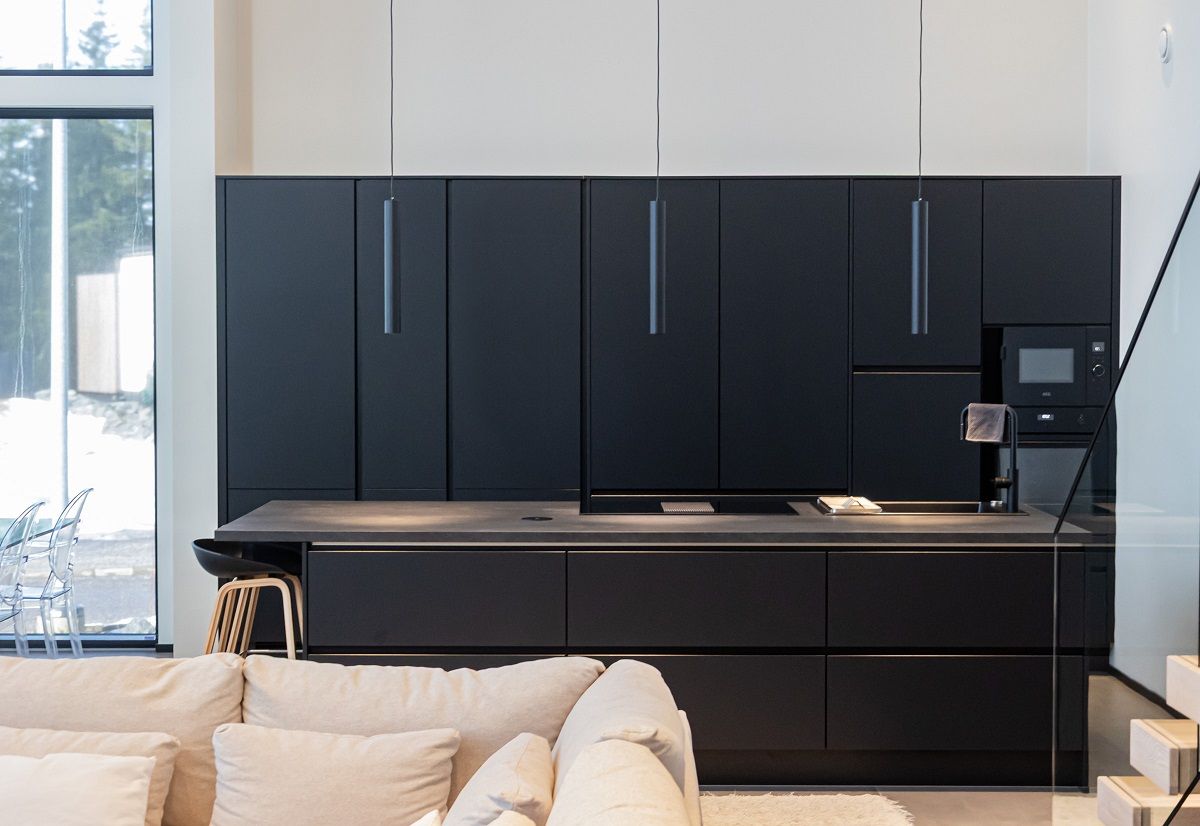 Three black PIPPEU 2.0 pendant lights above a black kitchen island