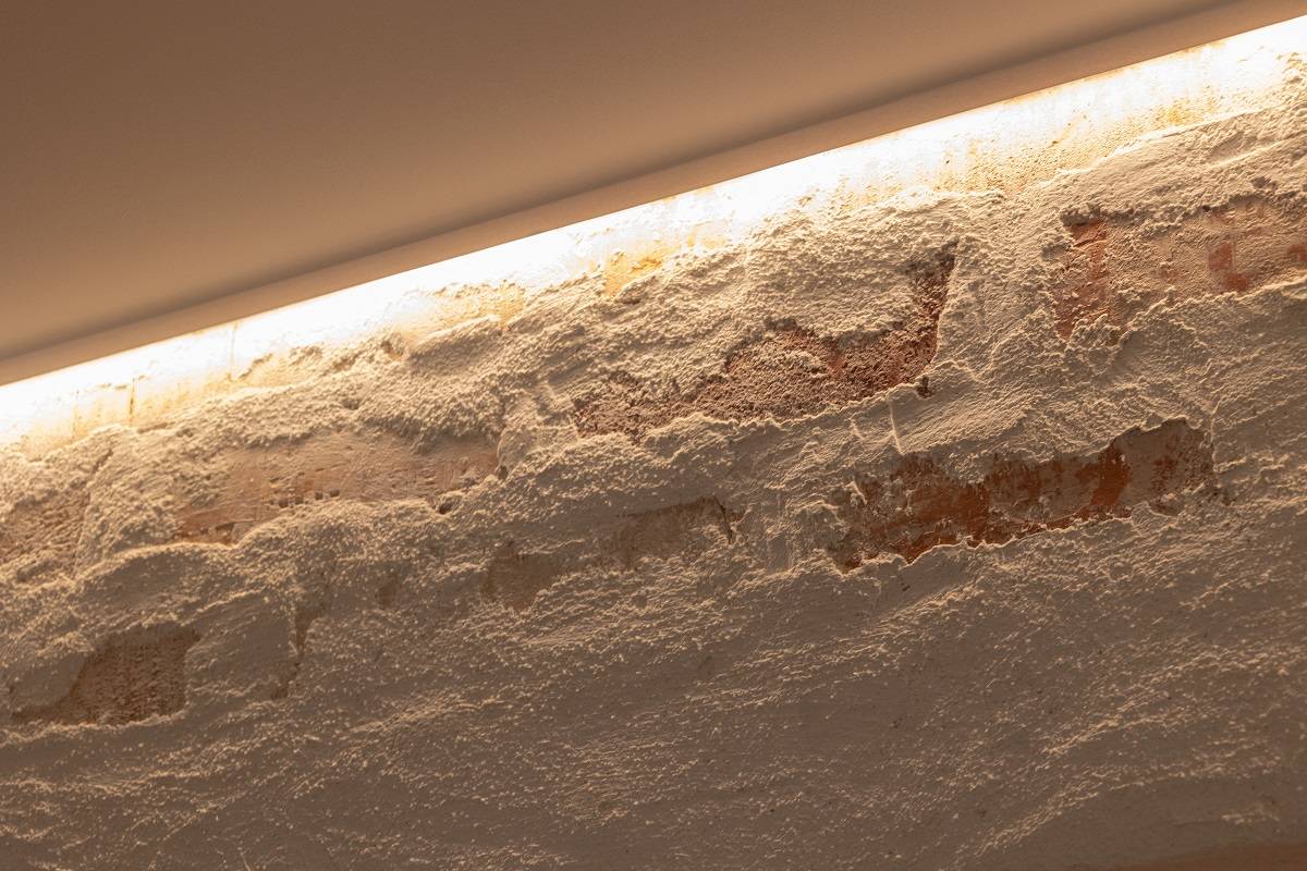 LED strip installed along the top edge of the accent wall to provide downward lighting.