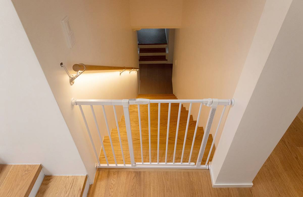 An LED strip installed under the stair railing casts light downward onto the stairs.