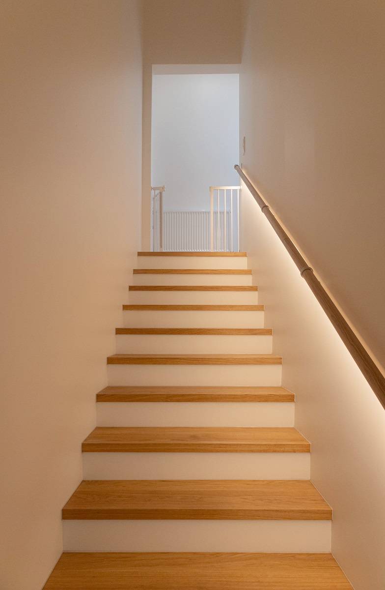 The stairs are illuminated by an LED strip placed under the handrail.