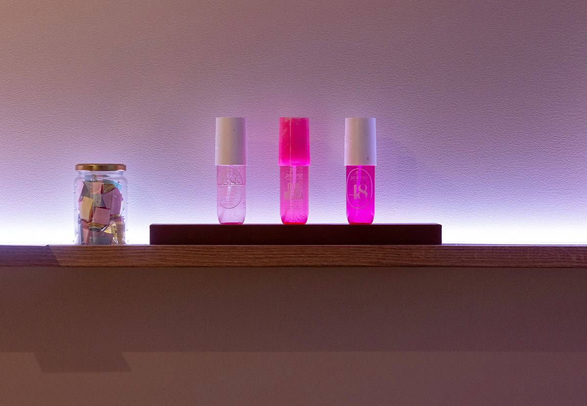 A color-adjustable LED strip installed behind the shelf casts a purple glow on the wall.