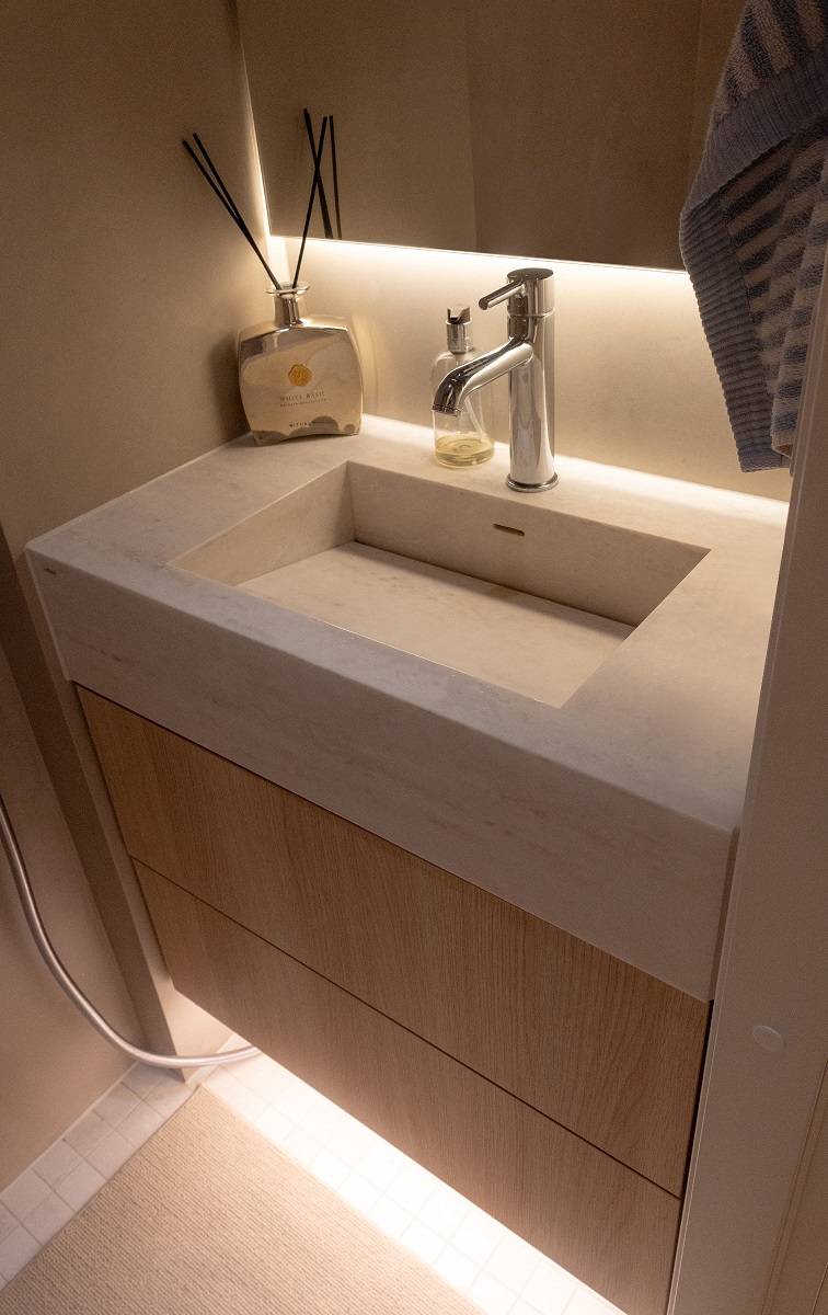An LED strip placed behind the mirror illuminates the countertop.
