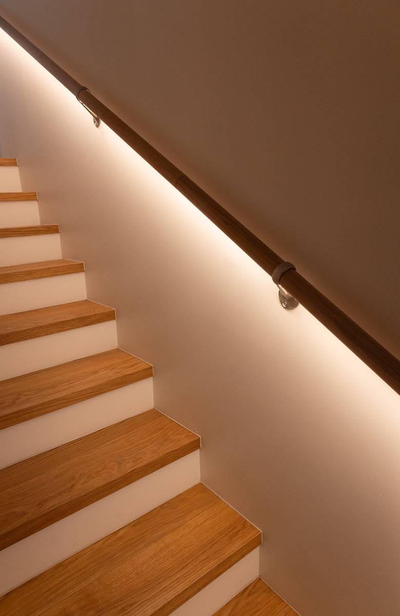 Light shines from under the railing on the stairs.