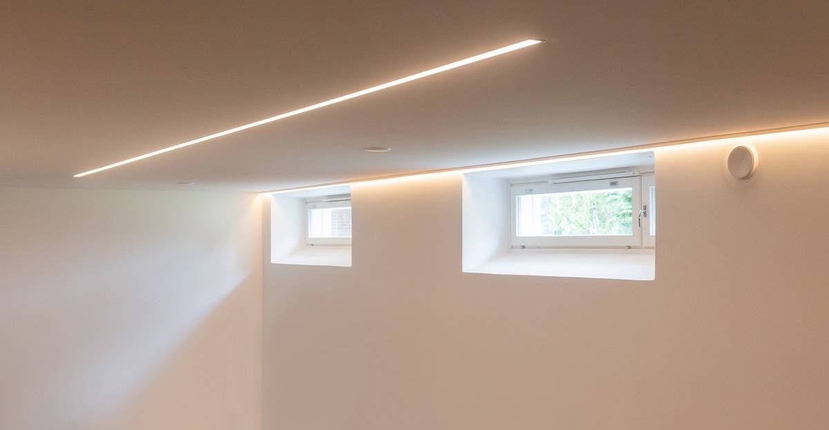 LED strip light installed next to the wall behind the trim and recessed in the center of the ceiling.