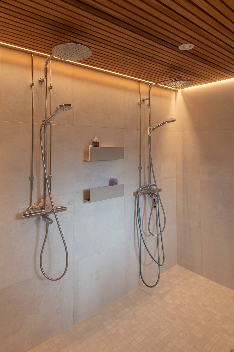 LED strip lighting along the ceiling edge in the bathroom. There is also a spot light on the ceiling that is not turned on.