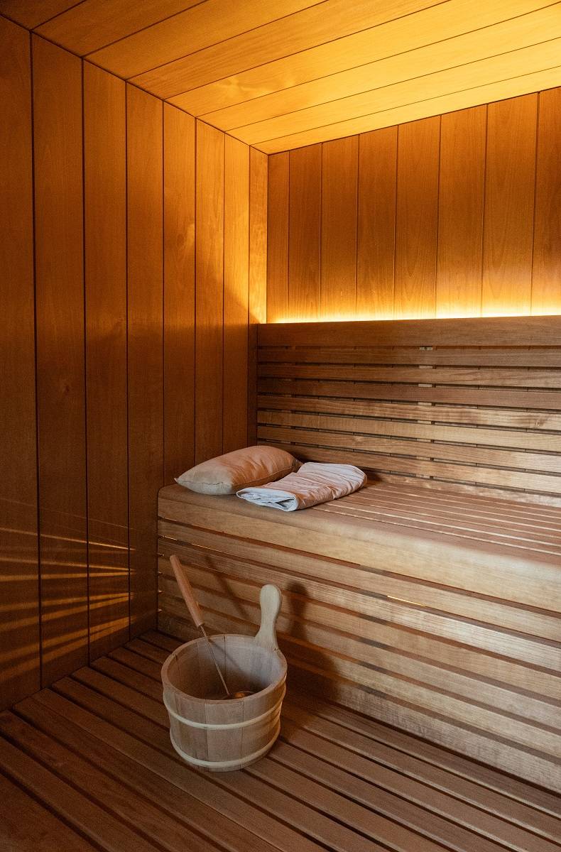 In the sauna, an LED strip lights up from behind the backrest. A light placed under the benches creates a beautiful pattern on the wall.