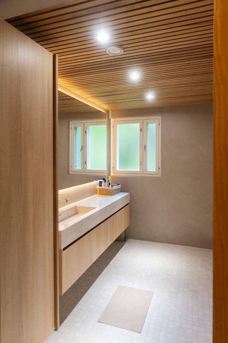 Spotlights on the bathroom ceiling and an LED light strip behind the mirror.