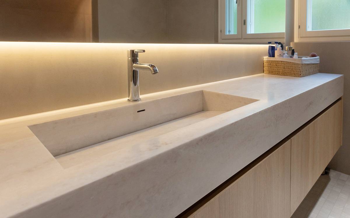 An LED strip placed behind the mirror illuminates the countertop.