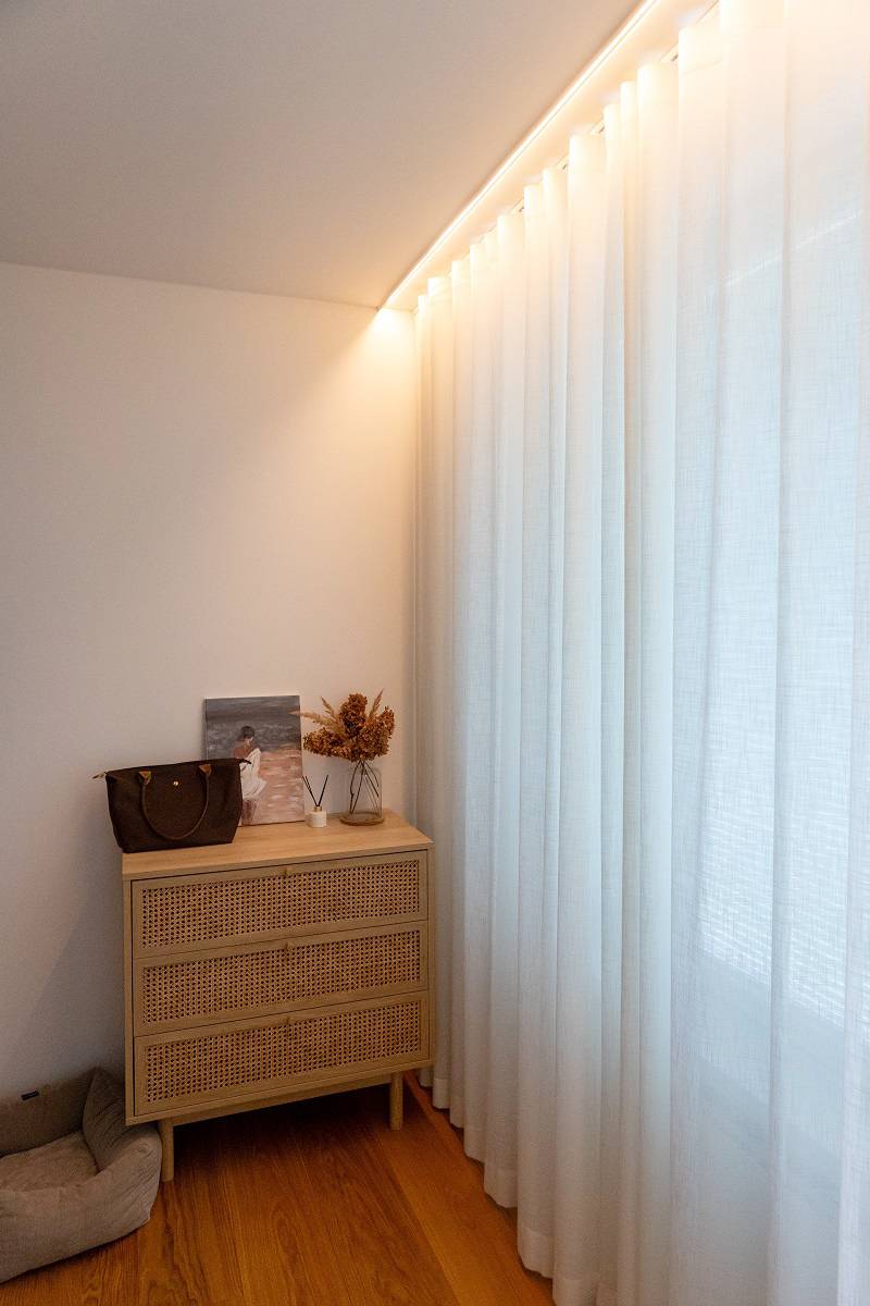 In the bedroom, an LED strip is also installed behind the trim, so the light source remains hidden.