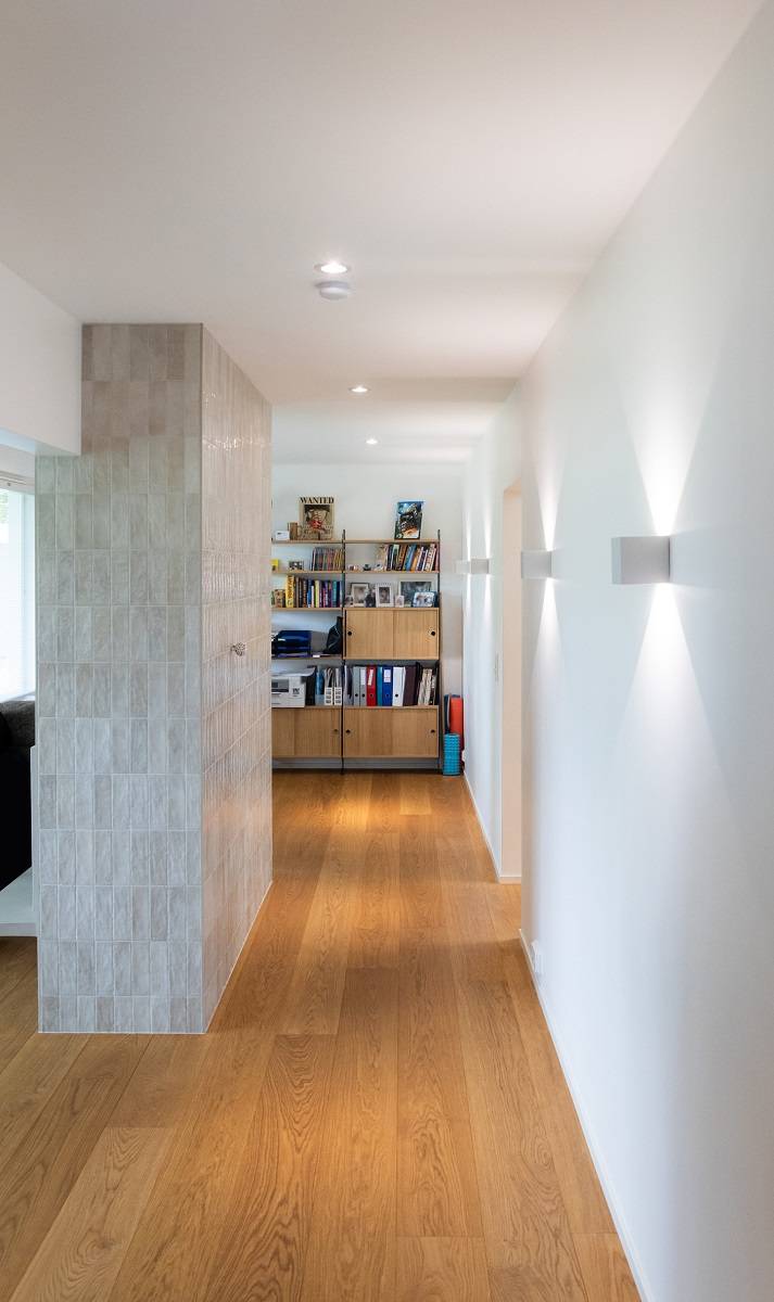 The hallway is lit by white spotlights and FUNK wall sconces.
