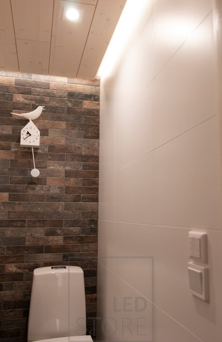 Spot lighting with LED downlight - LIGHT GREEN R023 and indirect lighting with white surface profile in the ceiling groove with 7,2 W/m CCT strip. A wireless controller mounted above the light switch is also visible on the wall.