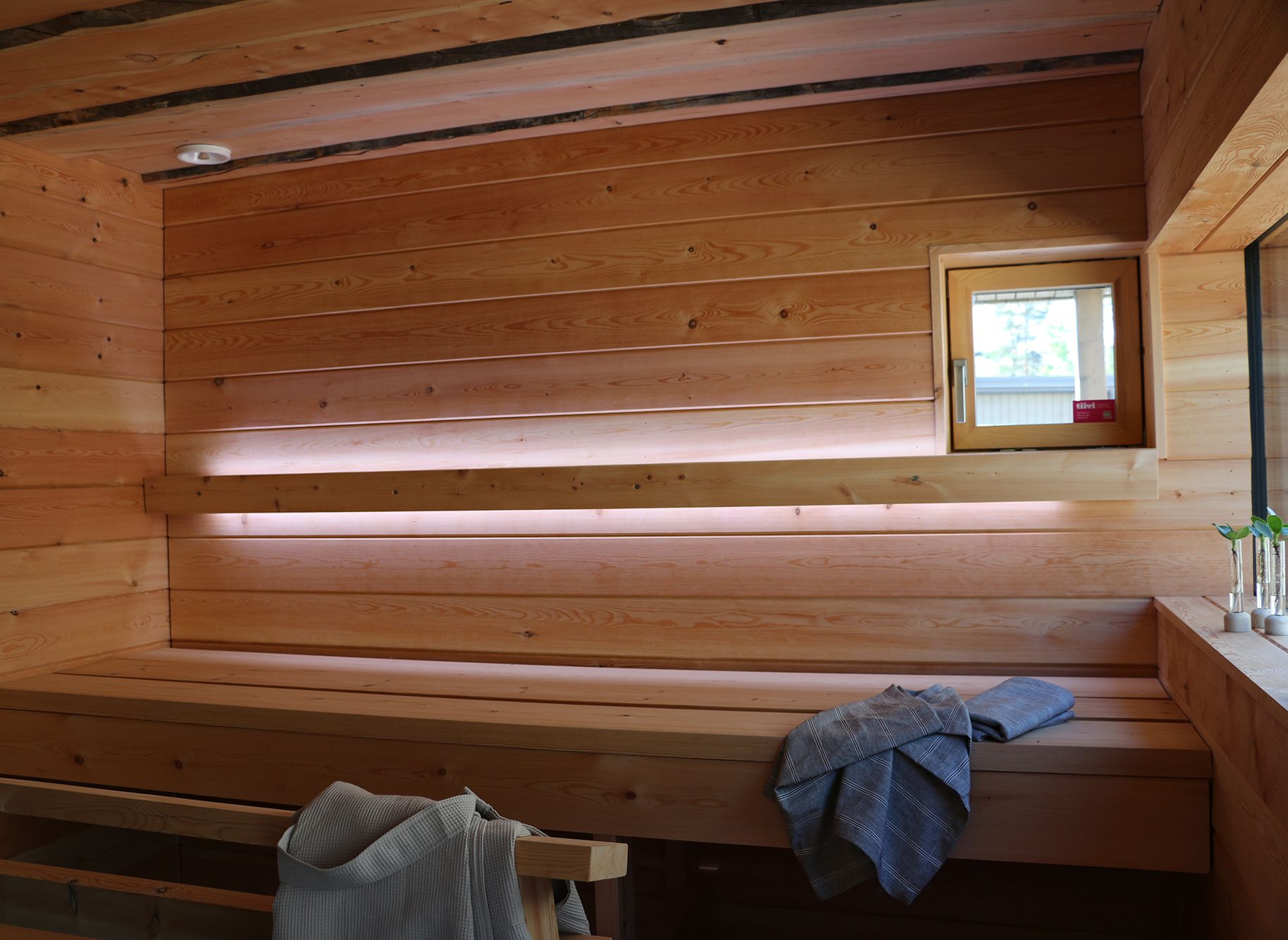 Sauna lighting implemented with led light strips on the backrest. Led strips illuminate upwards and downwards. Ledstore.fi