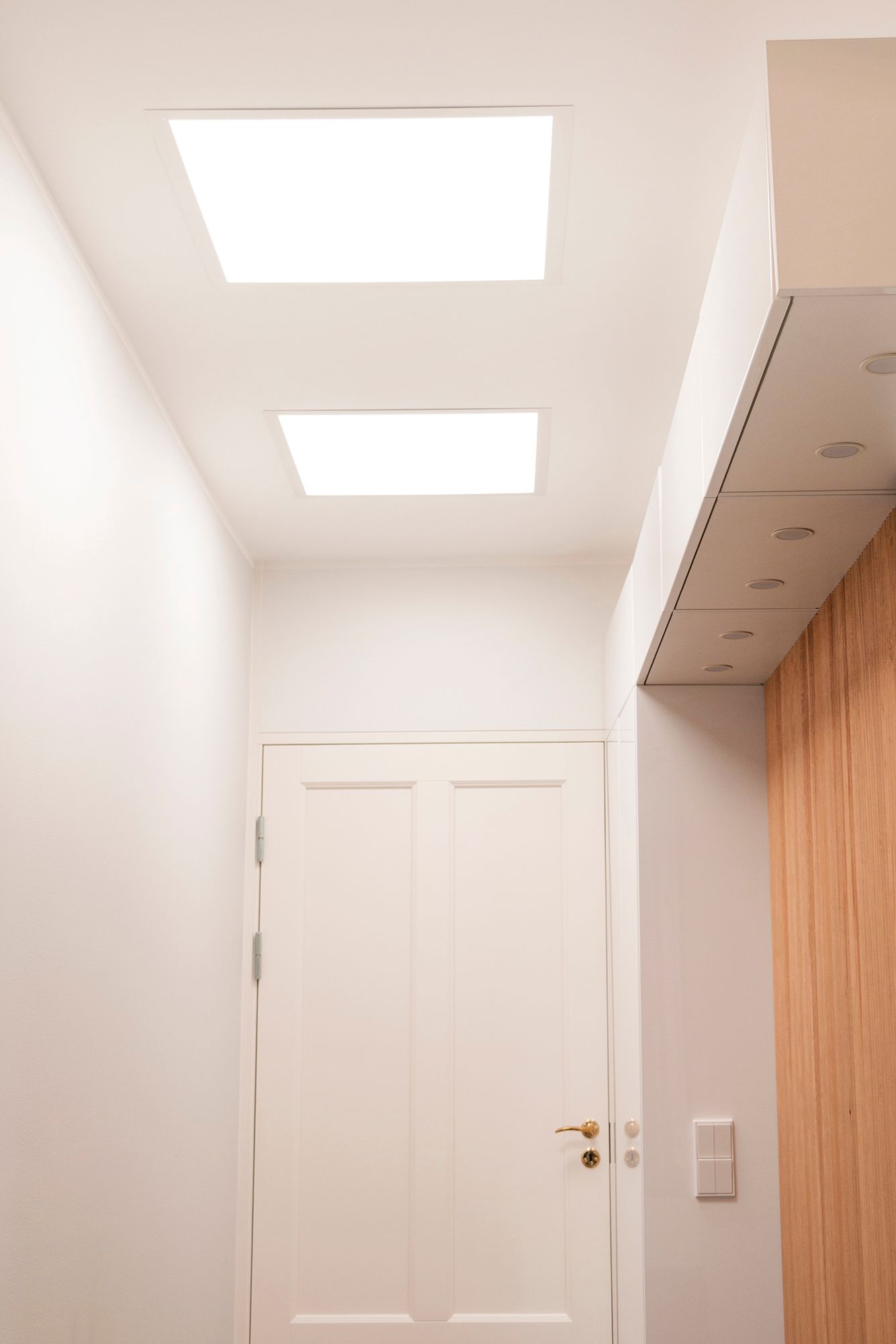 Two recessed led panels in the ceiling of the hallway.