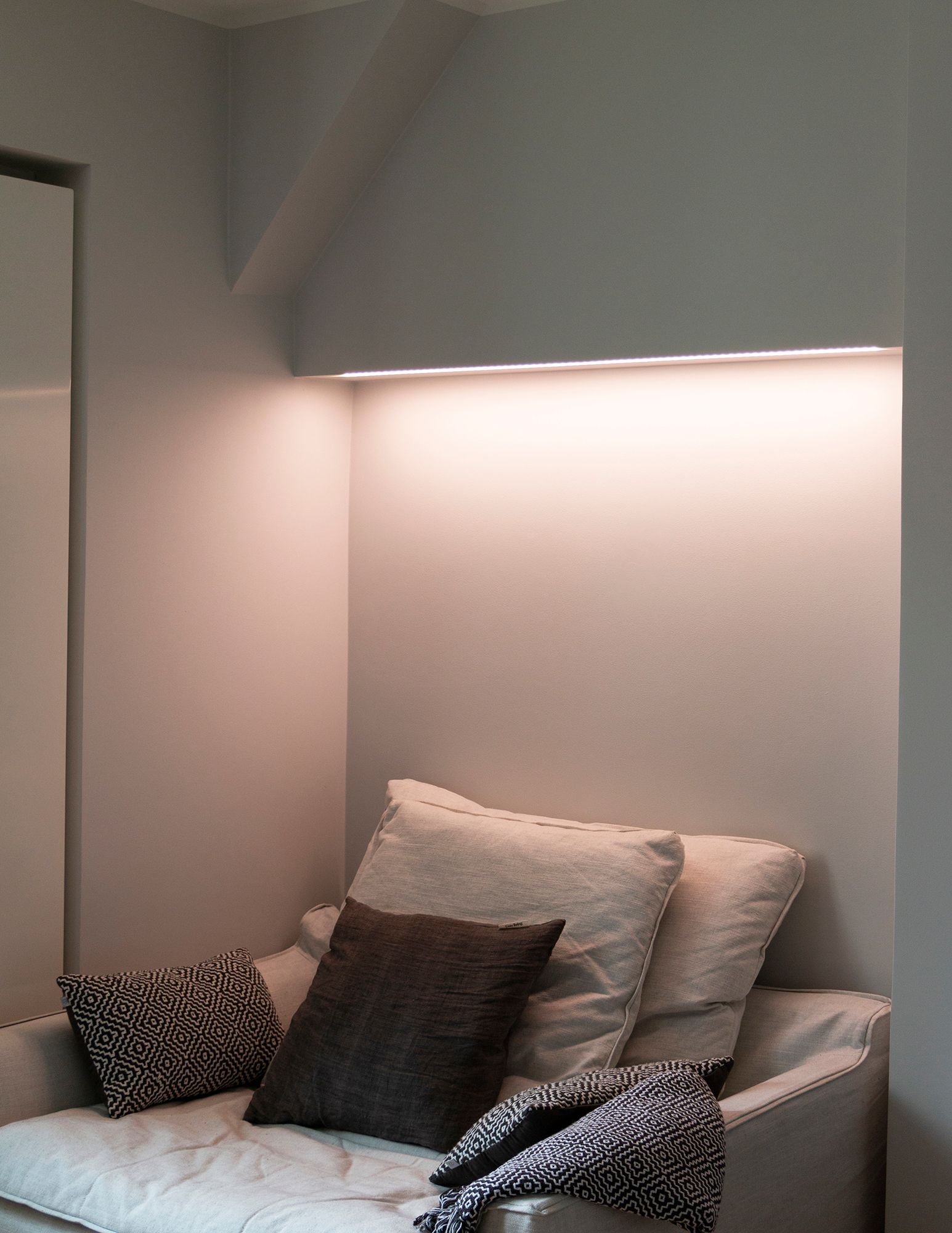 Bedroom with colour temperature adjustable mood lighting behind the bed, LED strip mounted on the bottom of the cabinet in a low profile surface. Ledstore.fi