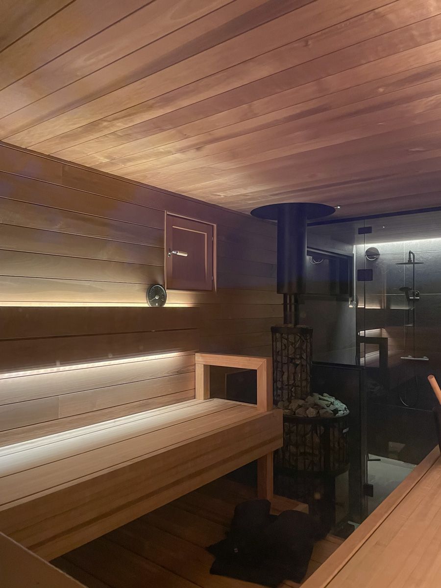 A fireplace with two LED strips behind the backrest. The light is reflected on the ceiling and the lower bath.