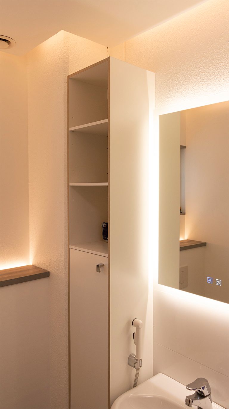 Indirect light in the bathroom. A light mirror combined with indirect light from the ceiling and an upward LED strip behind the toilet enclosure. Ledstore.fi