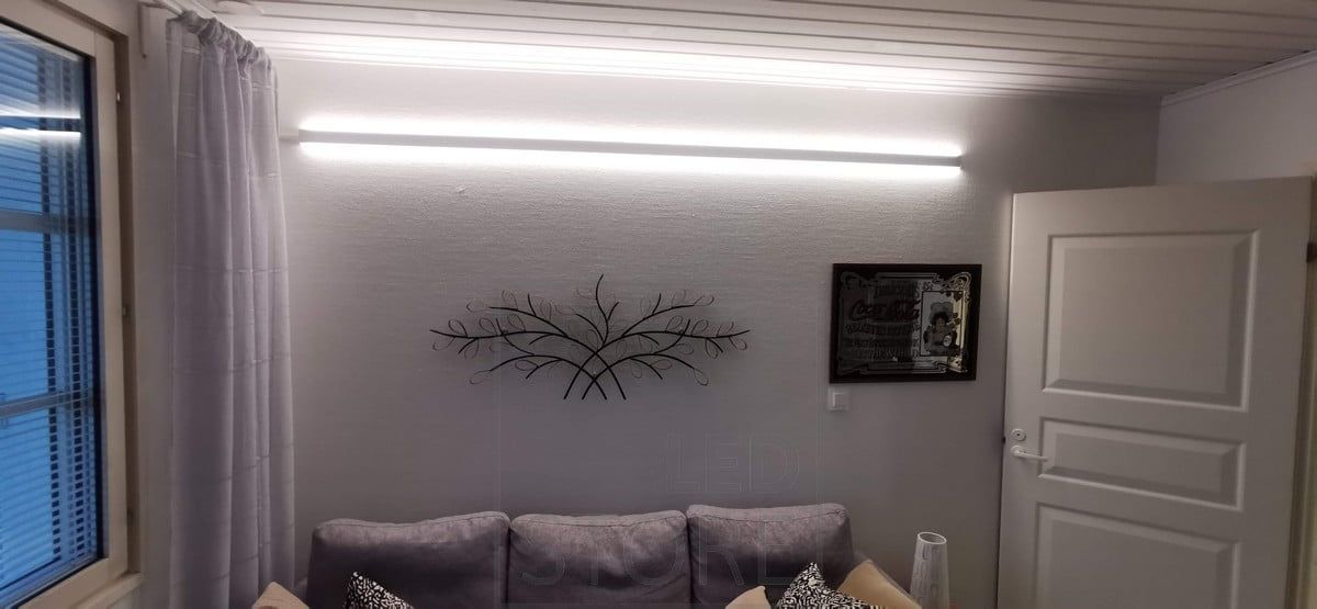 Behind the sofa, on the wall, a bi-directional LED profile. Two led strips on the profile. Ledstore.fi