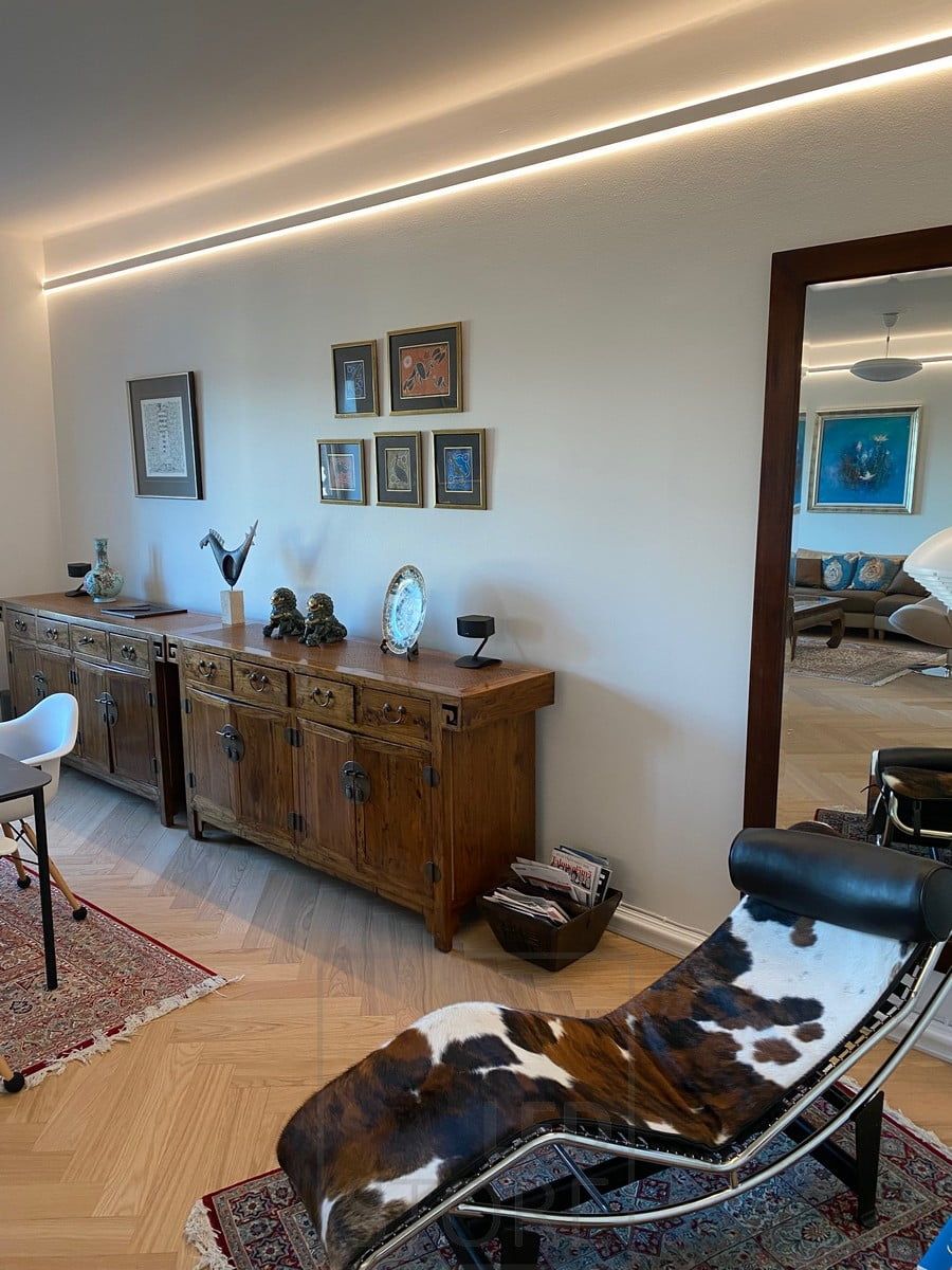 A two-way illuminated aluminium profile brought slightly down from the ceiling. Led strips provide indirect mood lighting throughout the space. Ledstore.fi
