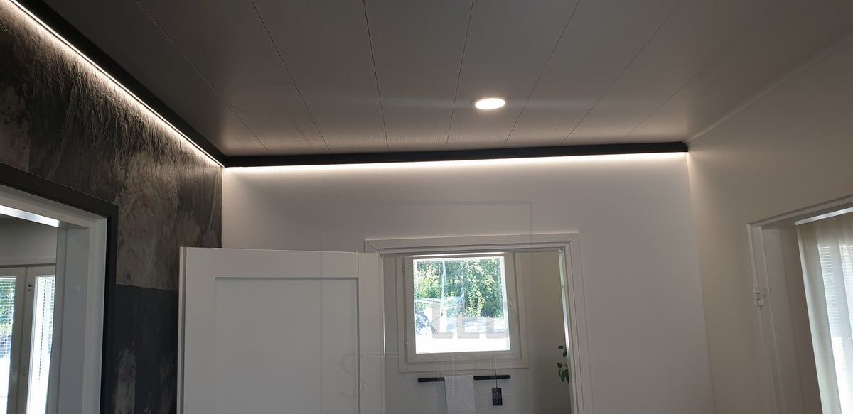 Decorative black wall profile with LED strip light providing indirect light. Ledstore.fi