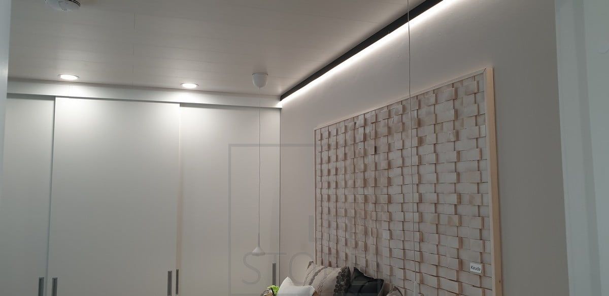 A black wall profile at the roof edge replacing the roof lath. Led strip light illuminating downwards indirect light through the wall. Ledstore.fi