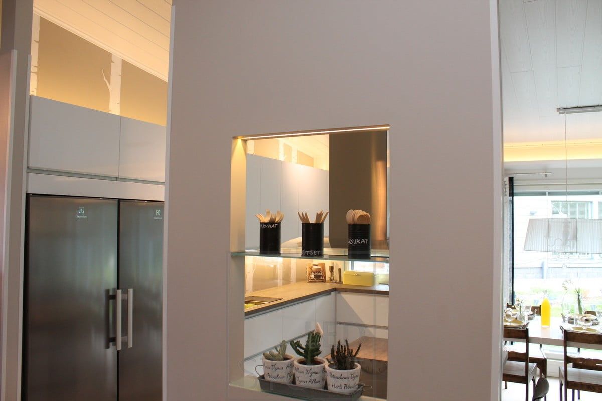Kitchen lighting with LED strips on the cabinets and countertop, and highlighting the beautiful shelf on the partition wall. Ledstore.fi
