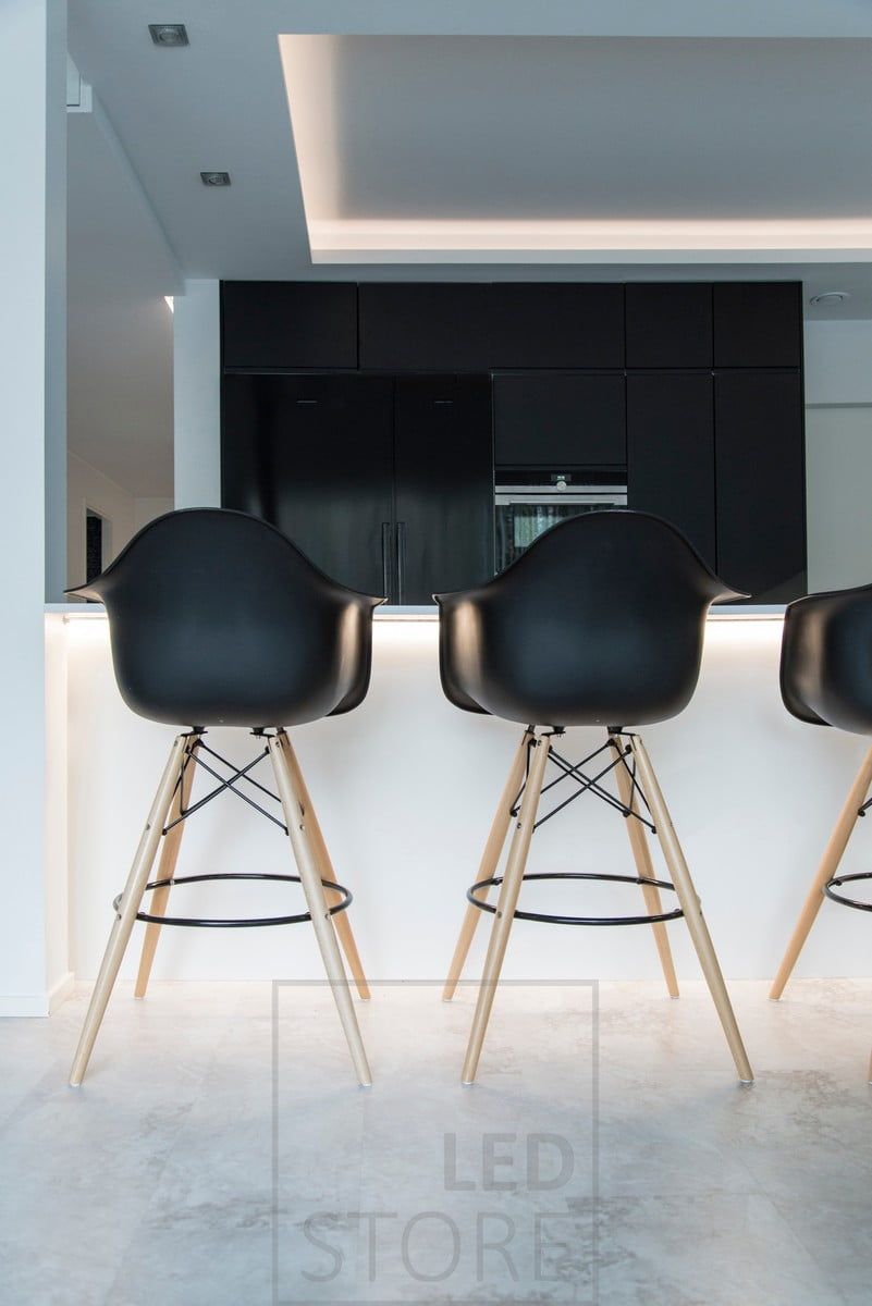 The island is highlighted by an LED ribbon on the island lip, the ceiling is illuminated by moody indirect lighting directed at the ceiling and the lowering is illuminated by spotlights. Ledstore.fi
