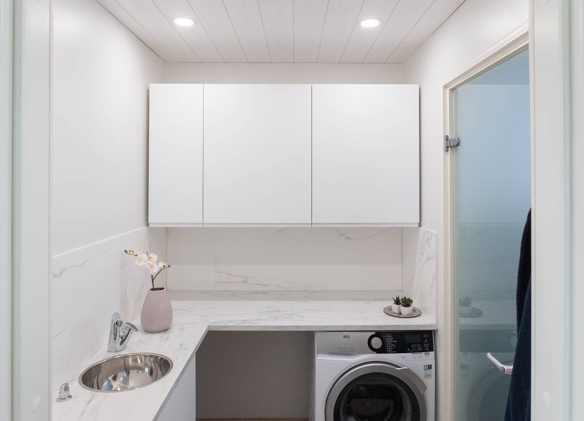 Small round panel lights flush mounted on the ceiling of a utility room.