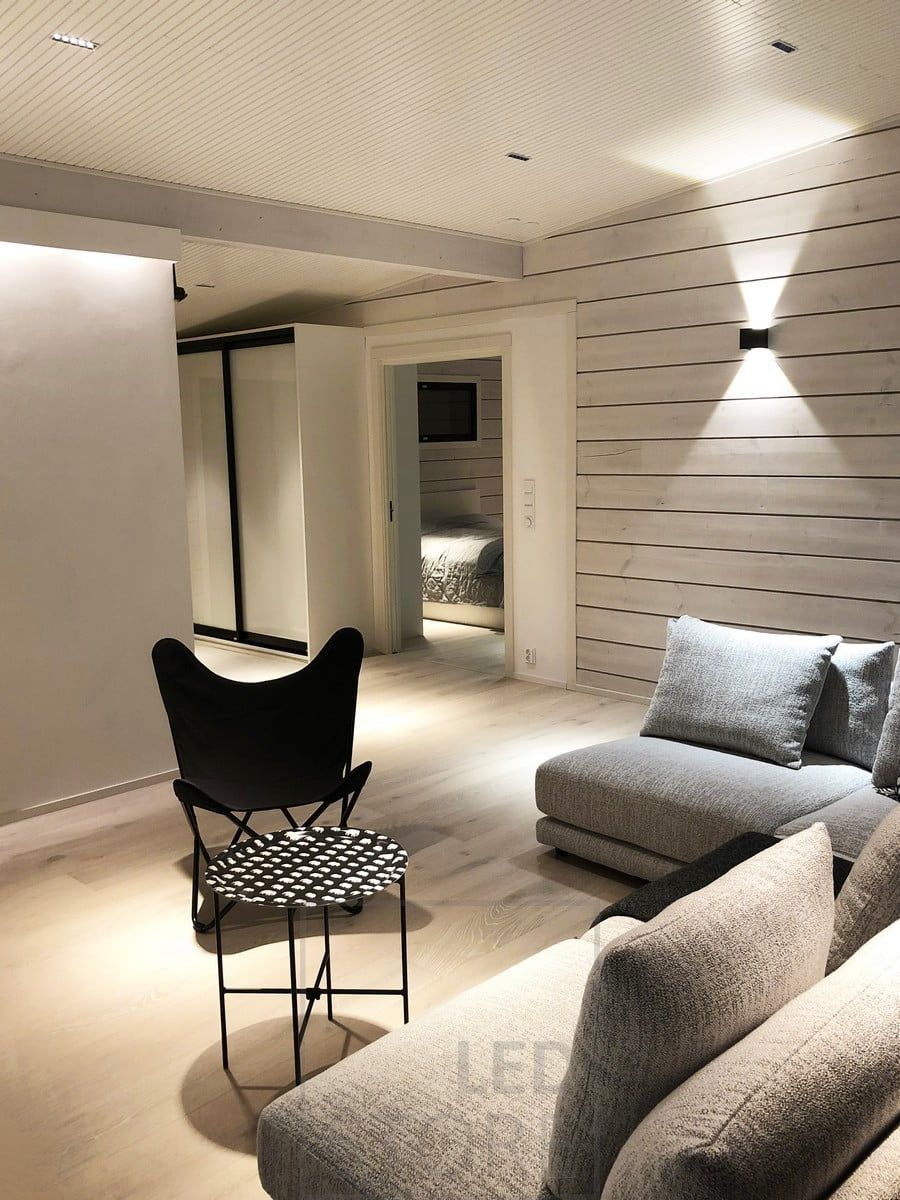 Atmospheric and versatile lighting in the living room. A LED strip behind the ceiling strip illuminates the space with indirect light, LINJA spots on the ceiling and a FUNK wall light on the wall. Ledstore.fi