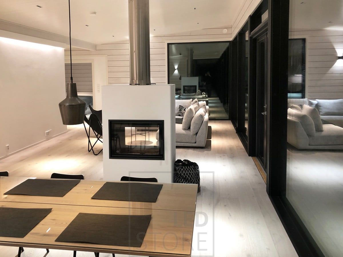 Atmospheric and versatile lighting. A LED strip behind the ceiling strip provides indirect light to the space, LINJA spots on the ceiling and a FUNK wall light on the wall. Pendant lights on the dining table. Ledstore.fi
