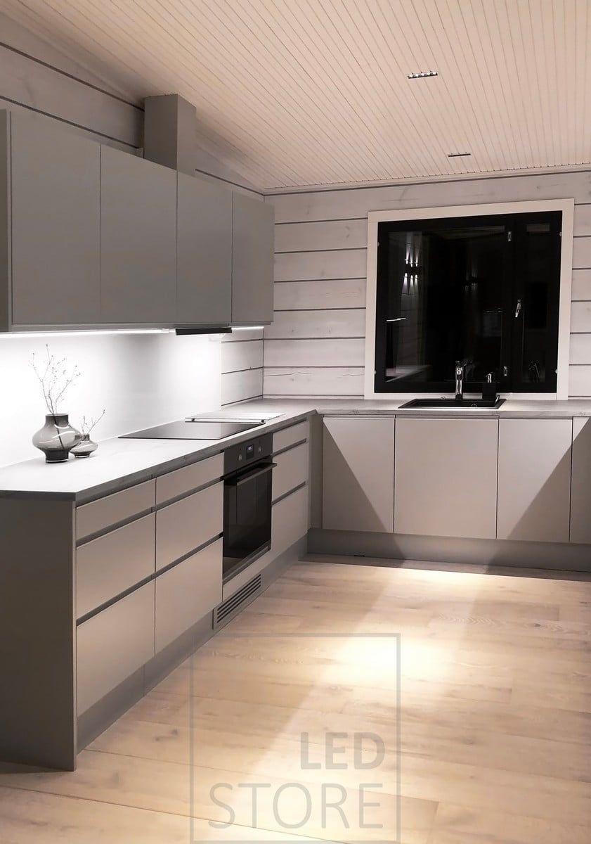 Kitchen lighting - at the bottom of the upper kitchen cabinets LED strip lights in aluminium profiles illuminating the worktops and LINJA spotlights in the ceiling. Ledstore.fi