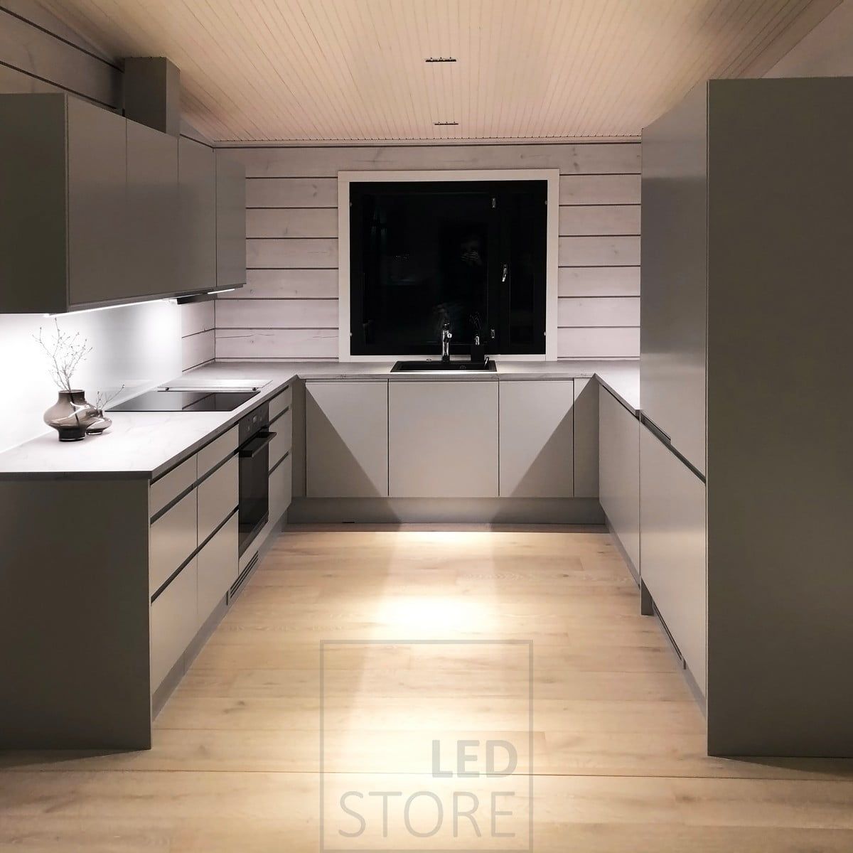 Kitchen lighting - LED strips on the bottom of the upper kitchen cabinets illuminating the worktops and LINJA spots on the ceiling. Ledstore.fi