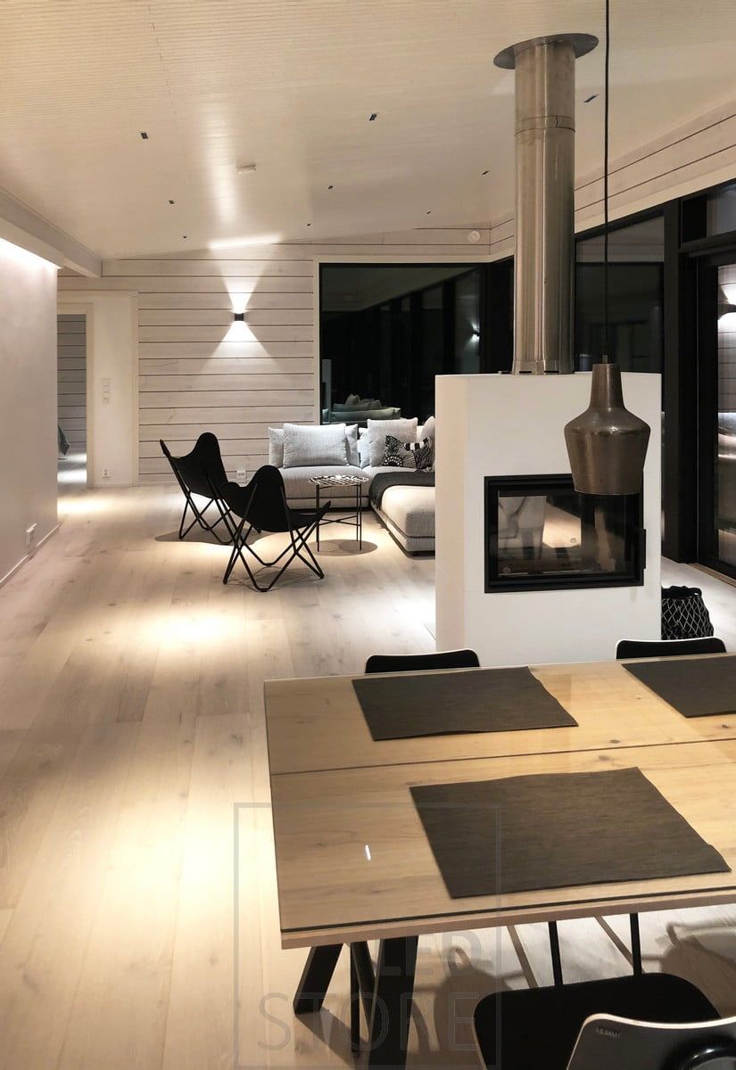 LINJA spots as ceiling lighting in the living room and dining area. In addition to the narrow-angle general lighting, the space is illuminated by FUNK wall lights, an LED strip between the ceiling and the wall, and decorative lights from the ceiling. Ledstore.fi