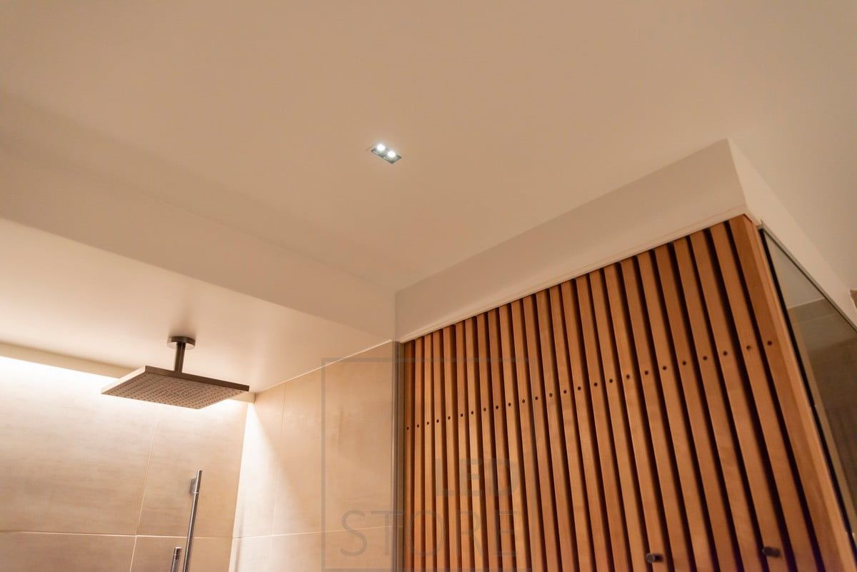 LINE 2 on the bathroom ceiling as a narrow-angle spotlight, behind the shower as mood lighting with a LED strip illuminating indirect light. Ledstore.fi