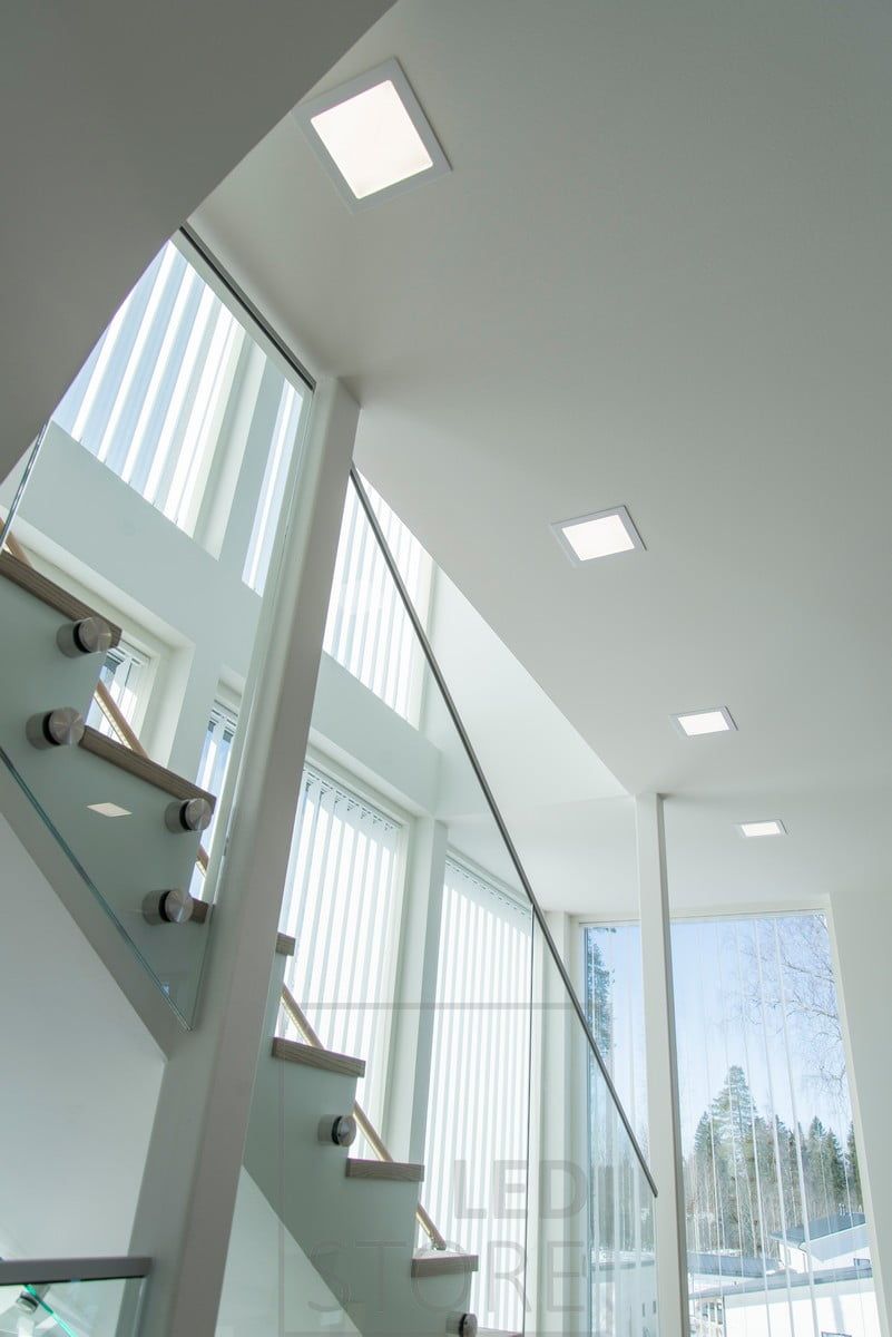 Next to the stairs, panel lights illuminate the space with uniform general lighting. Ledstore.fi