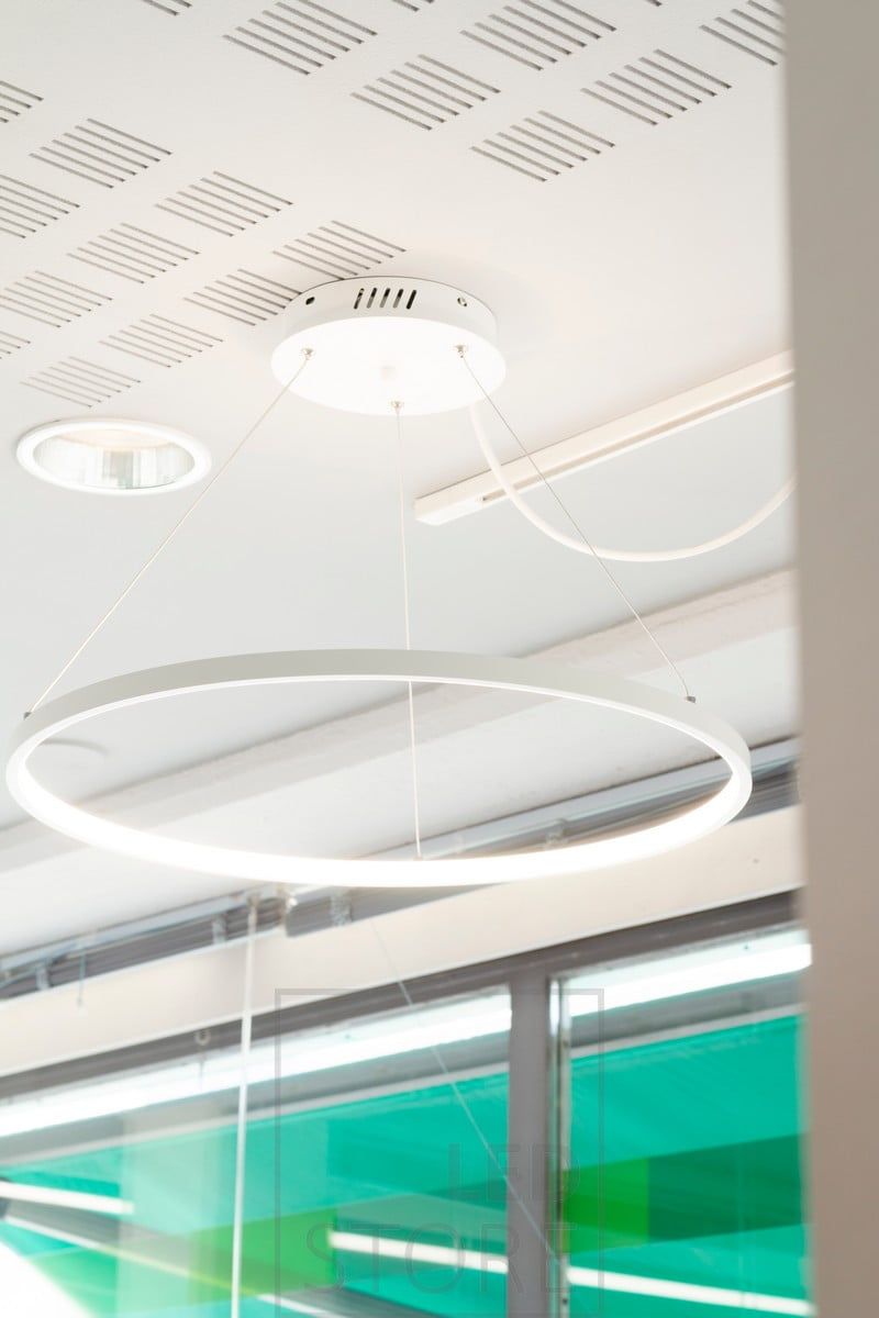 RINKELI pendant luminaire illuminating an office. The light comes through a white diffuser, from the inner ring of the luminaire. Ledstore.fi