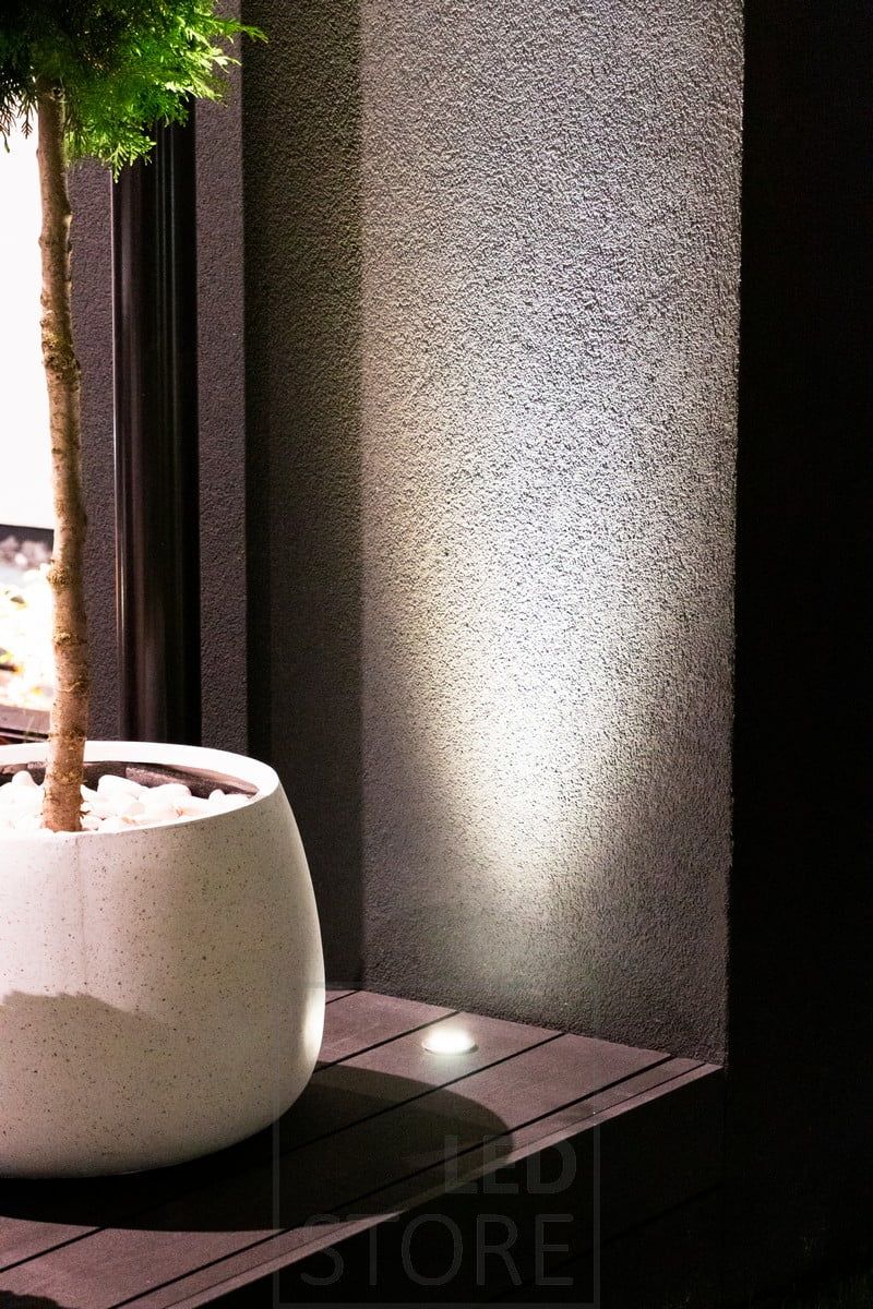 Plant and wall illuminating a patio pot with indirect light from the bottom up. Ledstore.fi