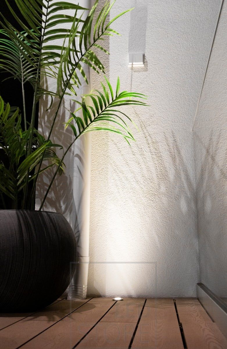 Recessed patio light close enough to the wall to create a reflective surface for the spotlight. Ledstore.fi